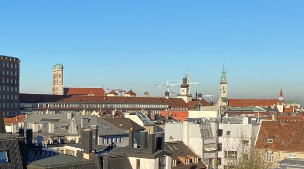 Un paisaje urbano con una mezcla de edificios históricos y modernos, incluyendo una torre destacada con una cúpula y un campanario.