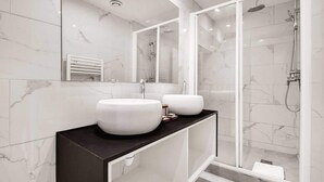 A modern bathroom with two large white sinks, a black countertop, and a glass-enclosed shower area. - Super appartment-2BR/6p-Bastille (Paris)