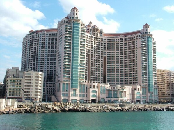 Un grand hôtel à plusieurs étages, doté d’une façade incurvée, situé près d’une étendue d’eau.