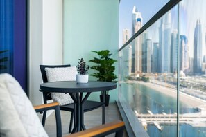 Ein Balkon mit einem runden Tisch, einem Stuhl und einem Blumentopf.