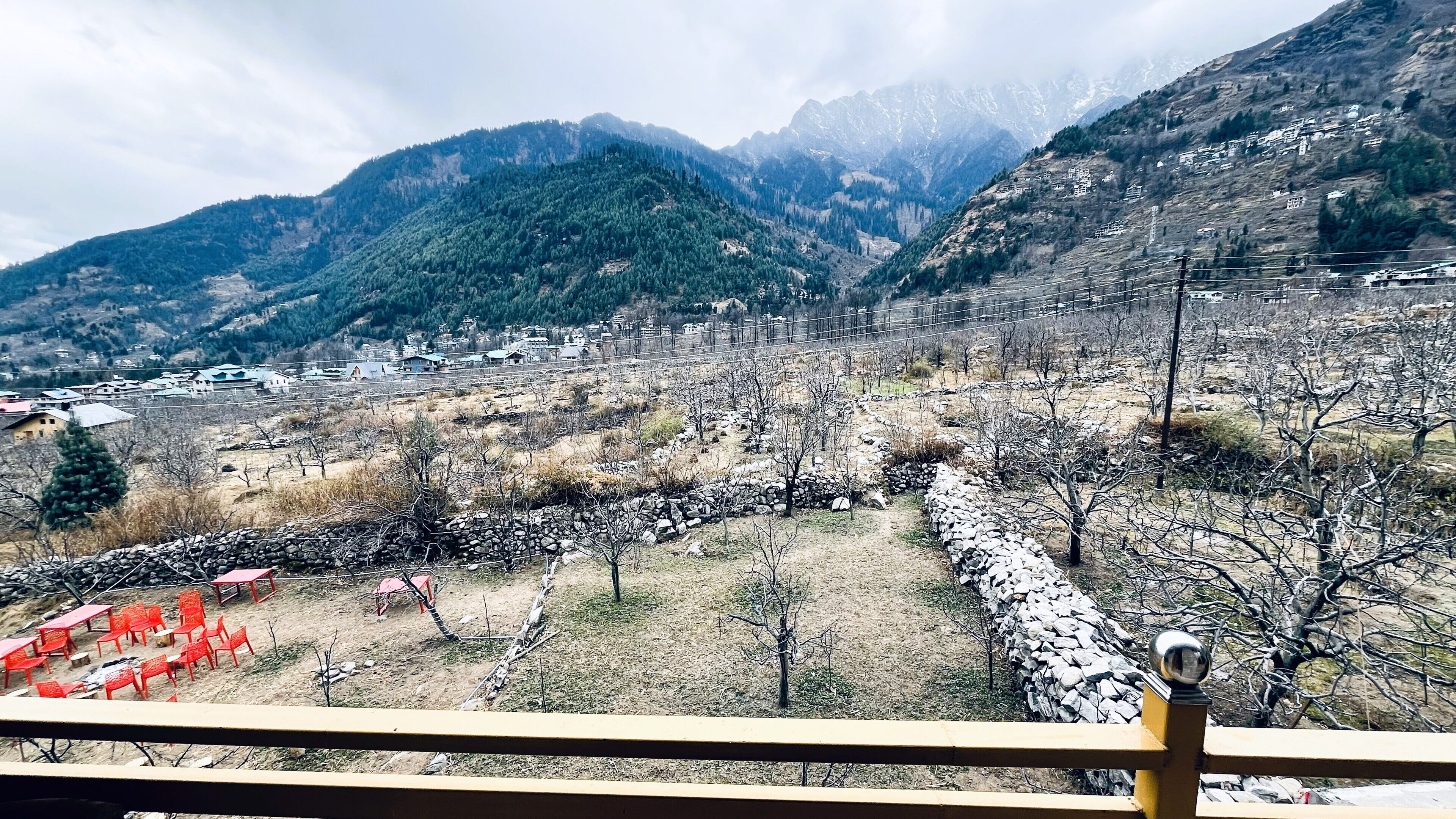 Un paysage montagneux avec un village, des murs de pierre et un ciel dégagé.