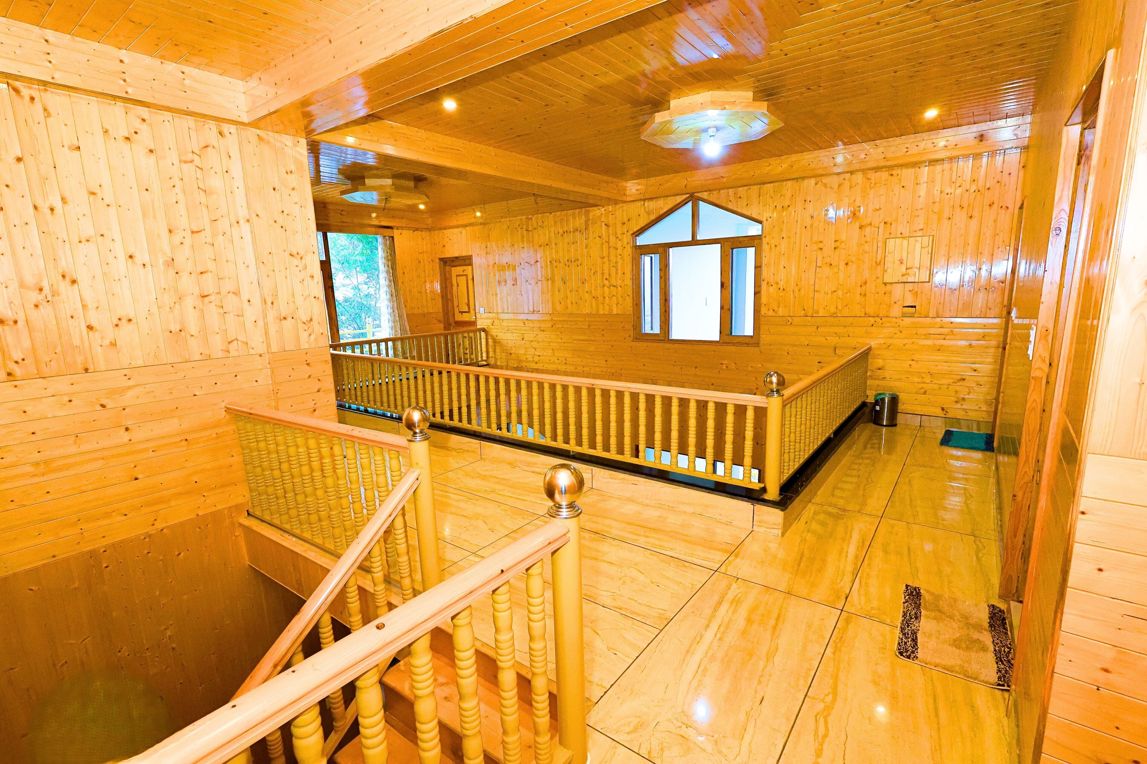 A wooden interior with a staircase, a window, and a ceiling light fixture.