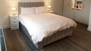A bedroom with a bed, nightstands, a wardrobe, and wooden flooring. - Stable Hill House,
5km from Killarney Town
Private & Peaceful Location
 (Killarney)