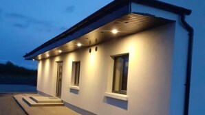 A modern building with a flat roof, multiple windows, and a paved entrance area. - Stable Hill House,
5km from Killarney Town
Private & Peaceful Location
 (Killarney)