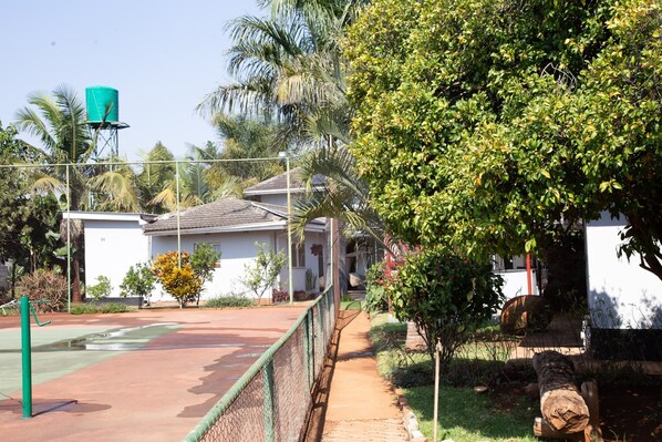 A residential area with a fenced playground, a water tank, and a house with a sloped roof. - Mt Pleasant Bed and Breakfast Ltd (Harare)