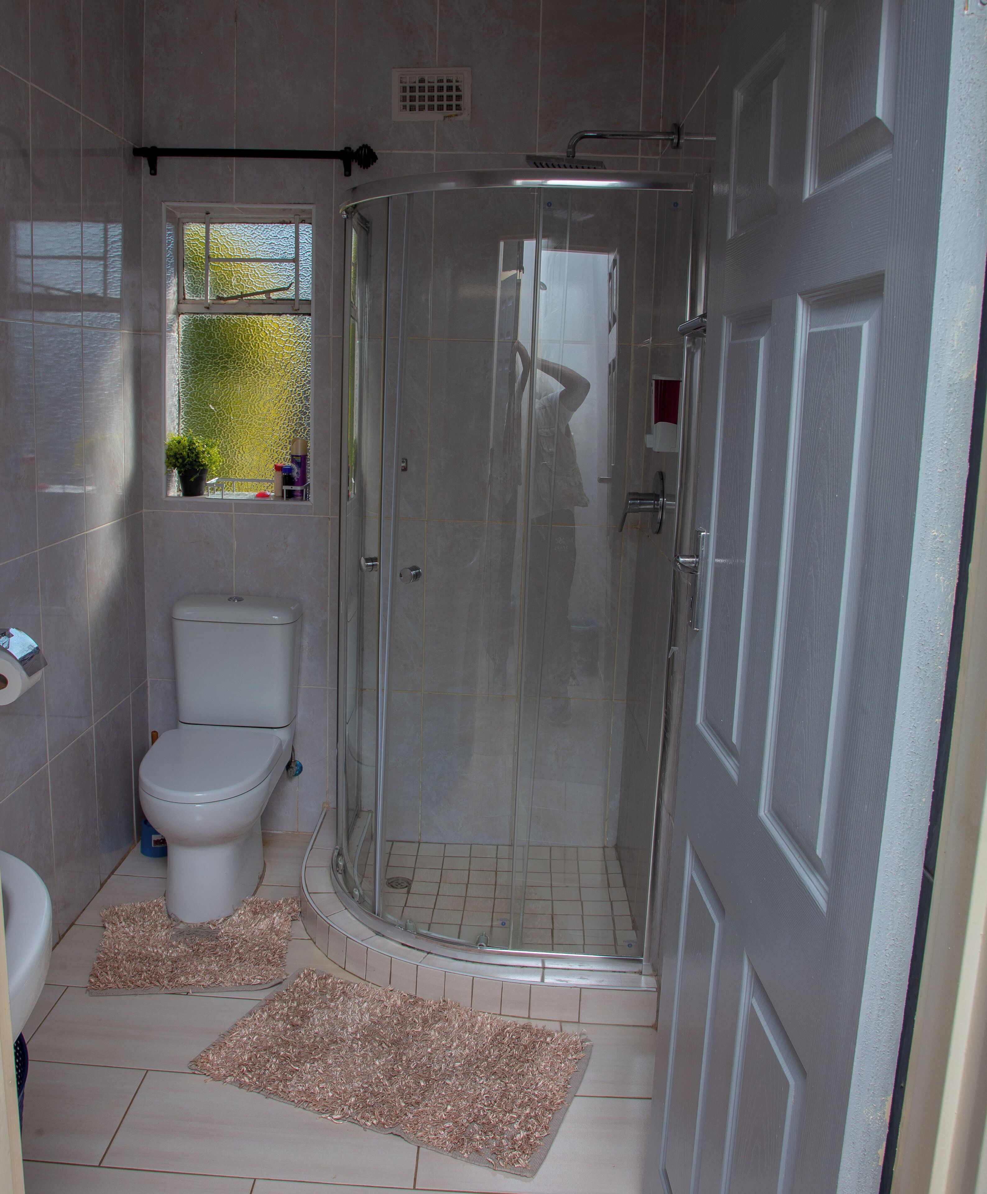 Une salle de bain avec des toilettes, une douche et un lavabo.
