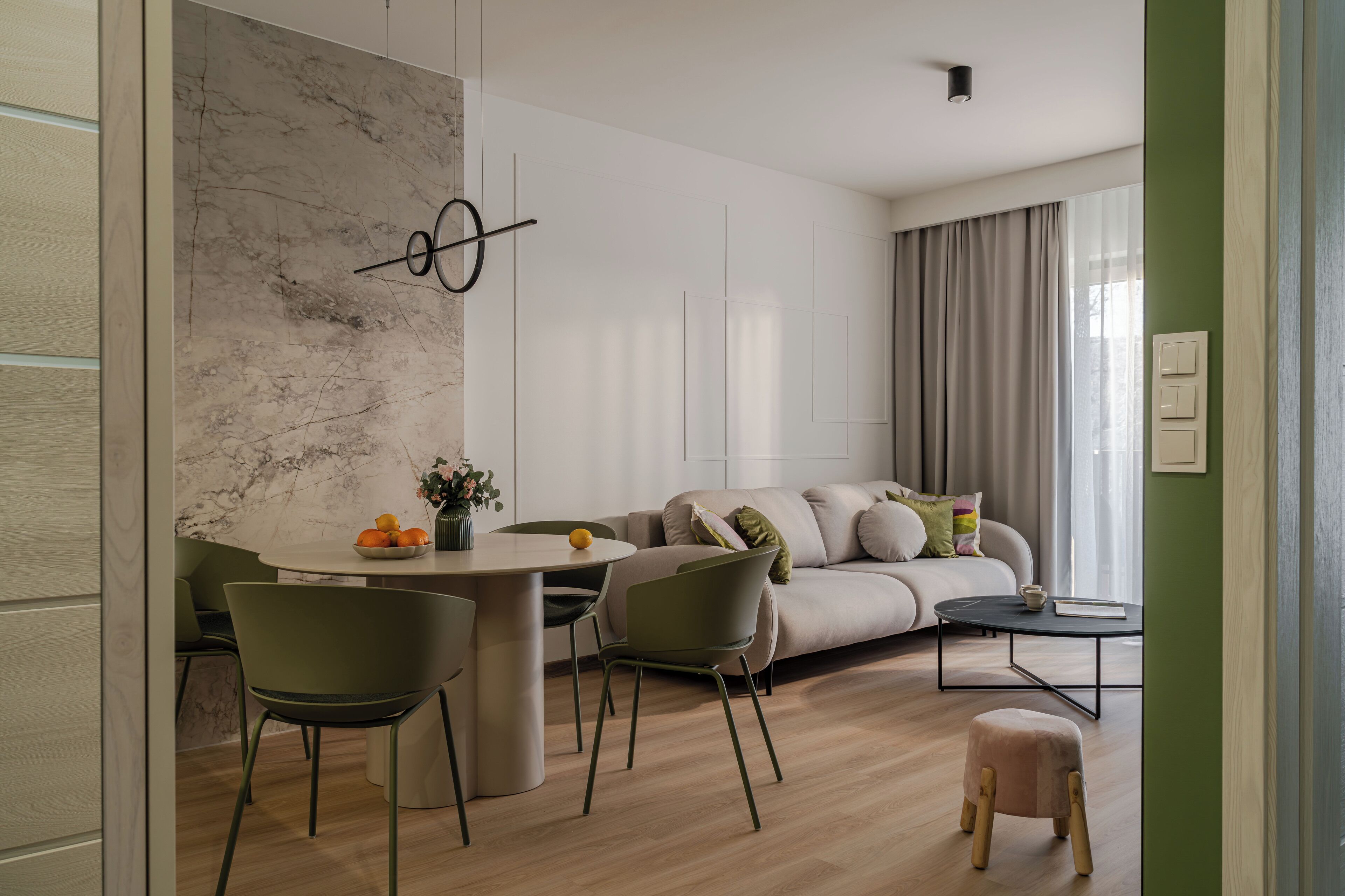 En moderne stue med sofa, spisebord og stole.