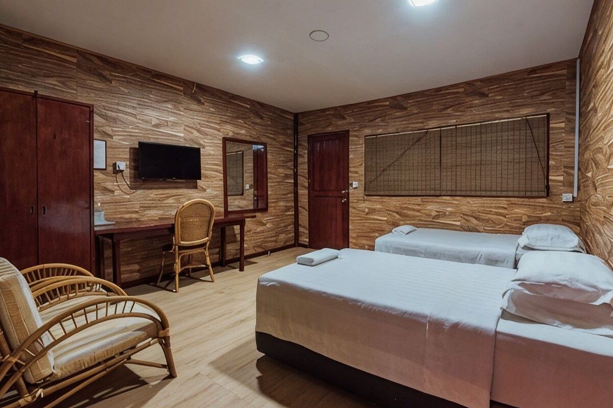 A hotel room with a wooden wall panel, a bed, a chair, a desk, and a television.