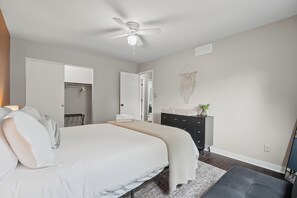 A bedroom with a bed, a dresser, a ceiling fan, and a wall-mounted macrame decoration. - Spacious Family & Work-Friendly 3BD w/ Workspace, Fire Pit & Park Views Near Campus (Champaign)
