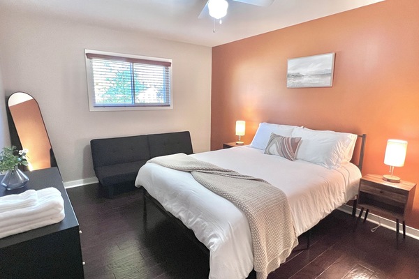Cozy queen size memory foam bed for a restful night's rest. Adjacent futon can also be folded out into a bed. Room also features a full length mirror and dresser.
