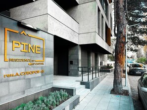 Welcome to Pine Residence by Capital, a sleek building with a geometric design and clean lines.