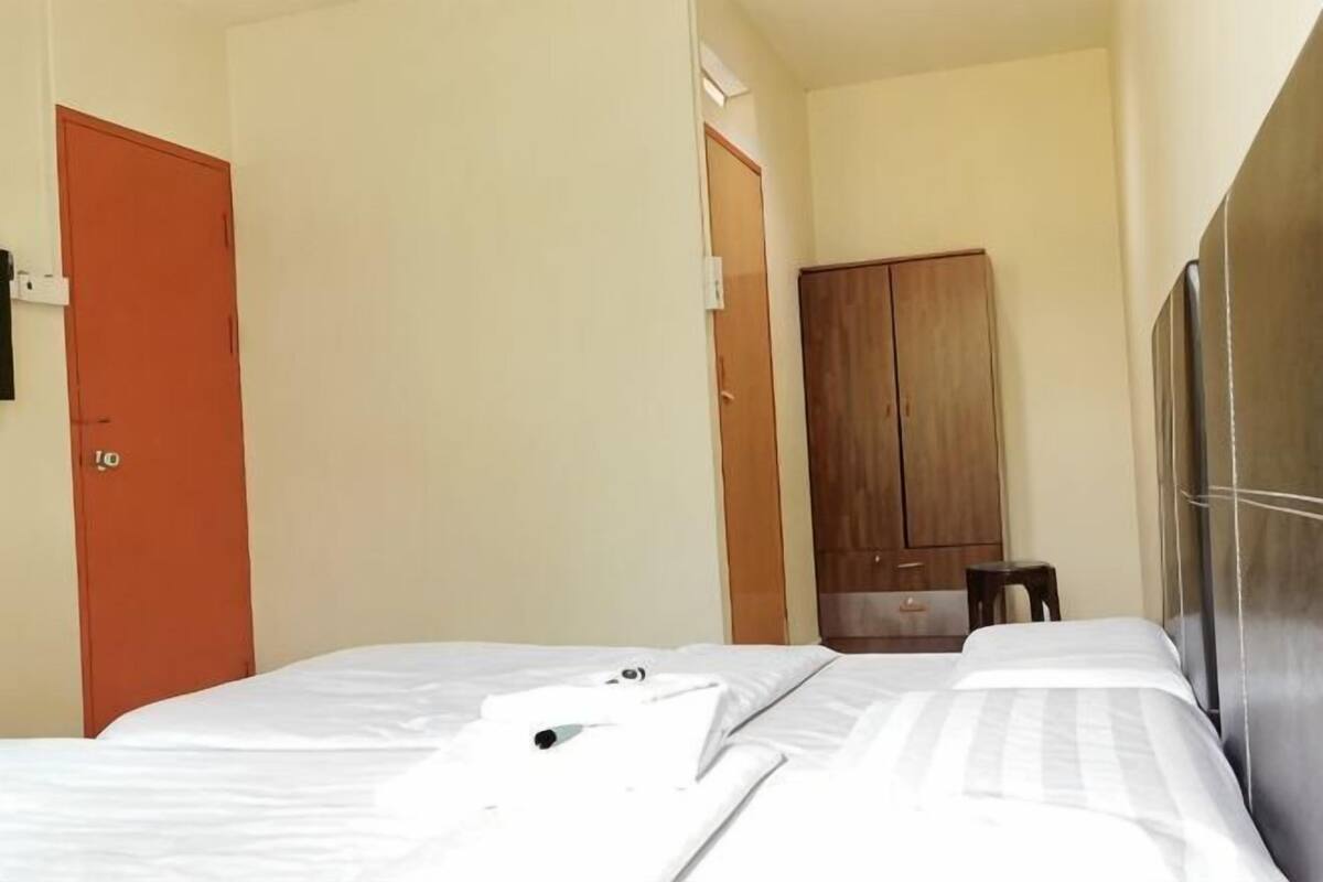 Una habitación de hotel con una cama, un armario y una puerta.
