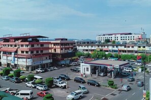 A multi-story building with a parking lot in front, surrounded by other buildings. - Hotel Ocean (Lahad Datu)