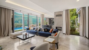 A spacious living room with a large blue sofa, a coffee table, and a fireplace.