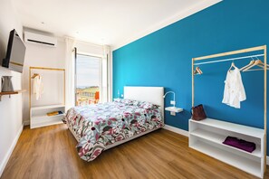 A bedroom with a bed, a wardrobe, a mirror, and a view of the outdoors. - Napoli Bellavista Apartment (Naples)