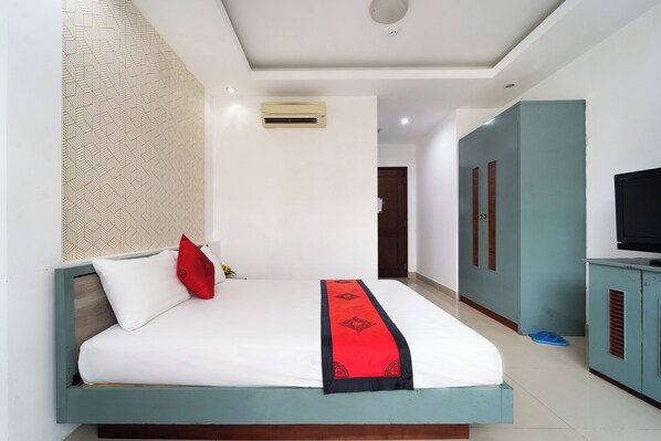 A bedroom with a bed, a TV, and a wardrobe.