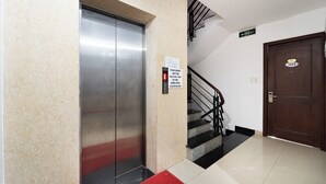 An elevator, a staircase, and a door with a number plate. - Collection O Cozy 5 Hotel - Near SECC (Ho Chi Minh City)