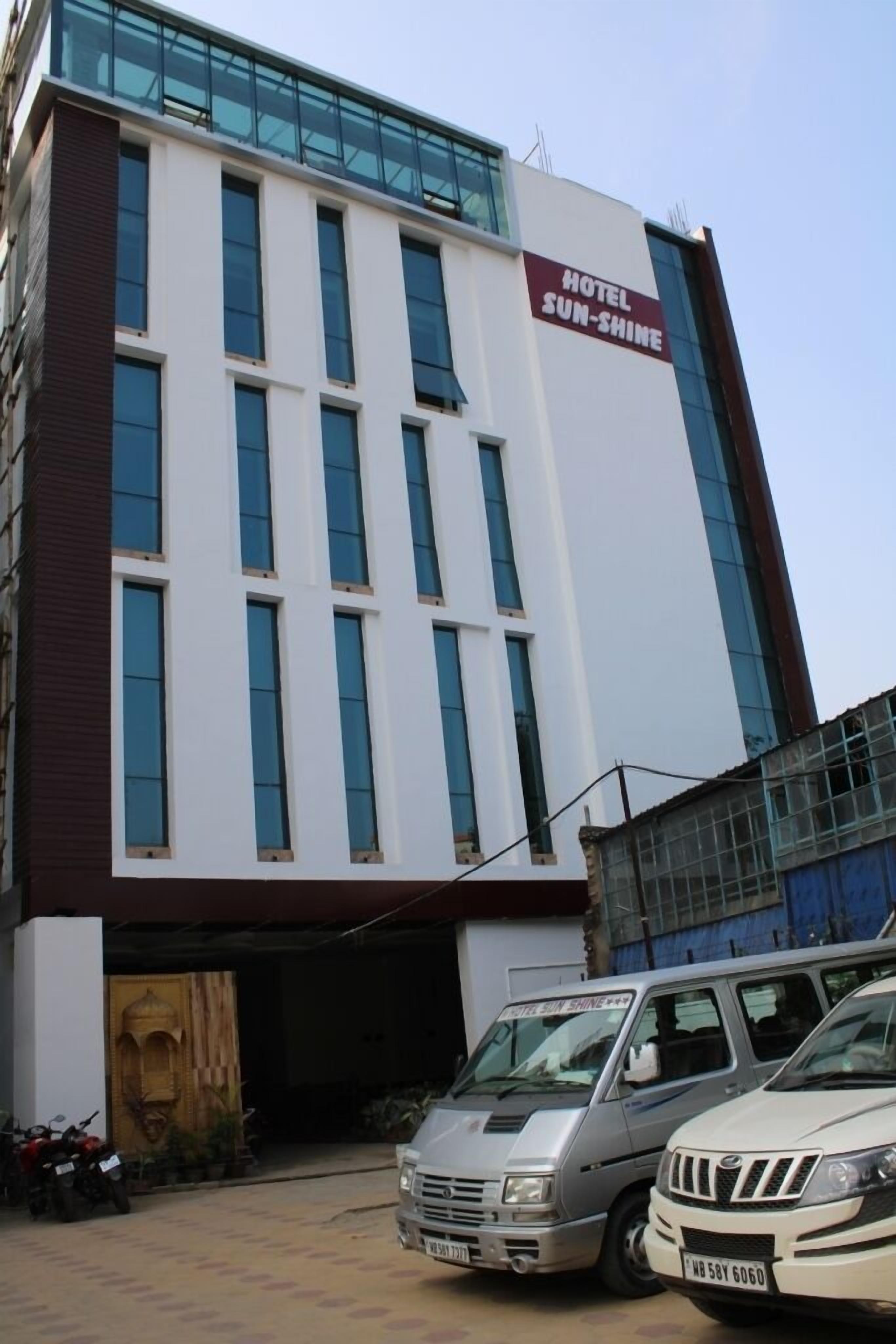 Un bâtiment d’hôtel moderne, sur lequel on peut lire l’inscription « HÔTEL SUN-SHINE ».