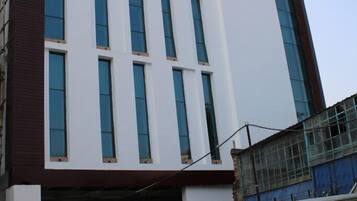 Un bâtiment d’hôtel moderne, sur lequel on peut lire l’inscription « HÔTEL SUN-SHINE ».