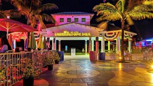 A nighttime view of a hotel entrance with a sign reading "LAUDERDALE-BY-THE-SEA." - Beach Walk Villa with Waterfall Pool LBTS (Lauderdale-by-the-Sea)