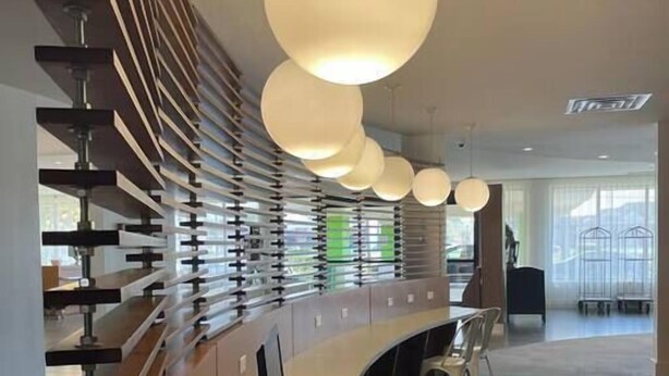 Un mostrador de recepción moderno con diseño curvo, una computadora y una silla.