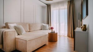 A modern living room with a sofa, a round wooden side table, and a decorative vase. - Nice home in Vukanovec with sauna (Vukanovec)