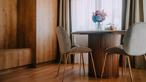 A dining area with a wooden table, two chairs, and a vase of flowers. - Nice home in Vukanovec with sauna (Vukanovec)