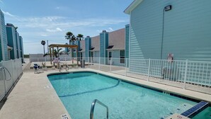 A swimming pool with a 3 FT depth marking, surrounded by a white fence, and adjacent to a building with a light blue exterior. - Canal Views & Pool | 2 Min to Beach | Fishing Pier (Corpus Christi)