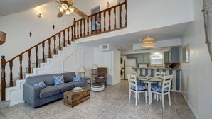 A spacious living area with a staircase, a dining set, and a kitchen. - Canal Views & Pool | 2 Min to Beach | Fishing Pier (Corpus Christi)