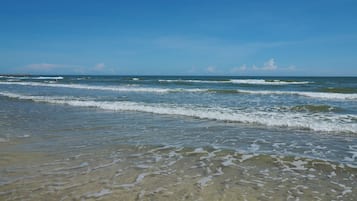 Uma praia com água cristalina e ondas.