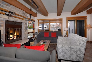 A cozy living room with a fireplace, a sofa set, and a view of a snowy mountain landscape. - Top Notch Plaza, Ski in/out, Hot tub, tennis (Mt. Crested Butte)