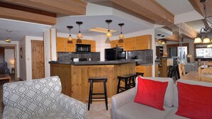 Een moderne keuken met houten kastjes, een centraal eiland en hanglampen.