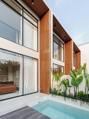 A modern house with a pool, large windows, and a wooden facade. - SOLAIR Beach Lofts Pererenan (Canggu)