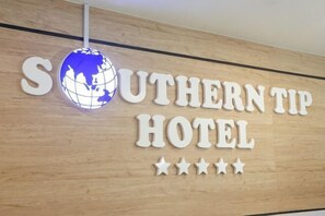A sign for the Southern Tip Hotel with a globe and stars. - Southern TIP Hotel (Pontian District)