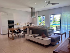 Ein modernes Wohnzimmer mit einer Couch, einem Esstisch und einer Küchenzeile.