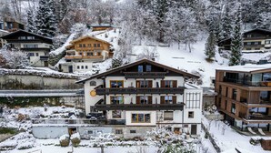 A multi-story hotel with balconies, a ski slope in the background, and snow-covered surroundings. - Apartments Haus Altenberger 1 Studio (Zell am See)