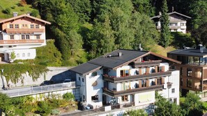 A multi-story building with balconies, surrounded by dense forest. - Apartments Haus Altenberger 4 Seeblick (Zell am See)