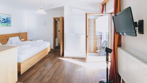 Habitación de hotel con cama de madera, escritorio, televisión de pantalla plana y vistas al exterior.