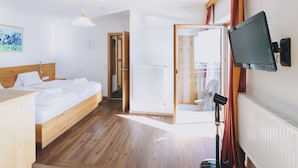 Une chambre d’hôtel avec un lit en bois, un bureau, un téléviseur à écran plat et une vue sur l’extérieur.