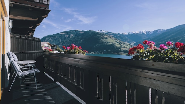 Un balcon avec vue sur un lac et des montagnes.