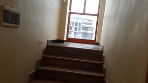 Eine Treppe mit Marmorstufen, die zu einem Fenster mit Blick auf Gebäude führt.