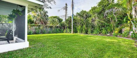 A well-maintained lawn with a patio area and a house with a covered porch.