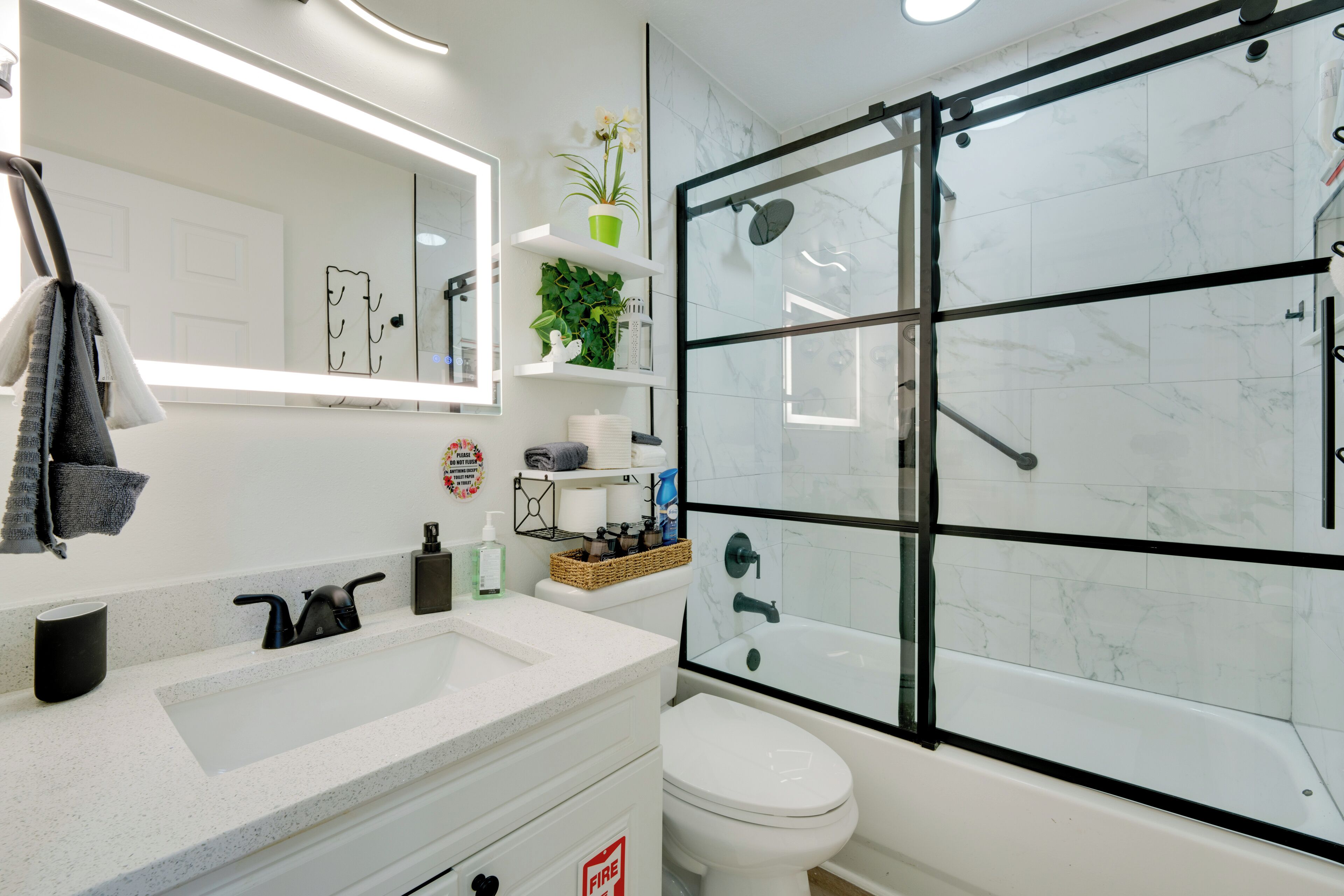 Un bagno moderno con un lavandino bianco, un water e una cabina doccia in vetro.