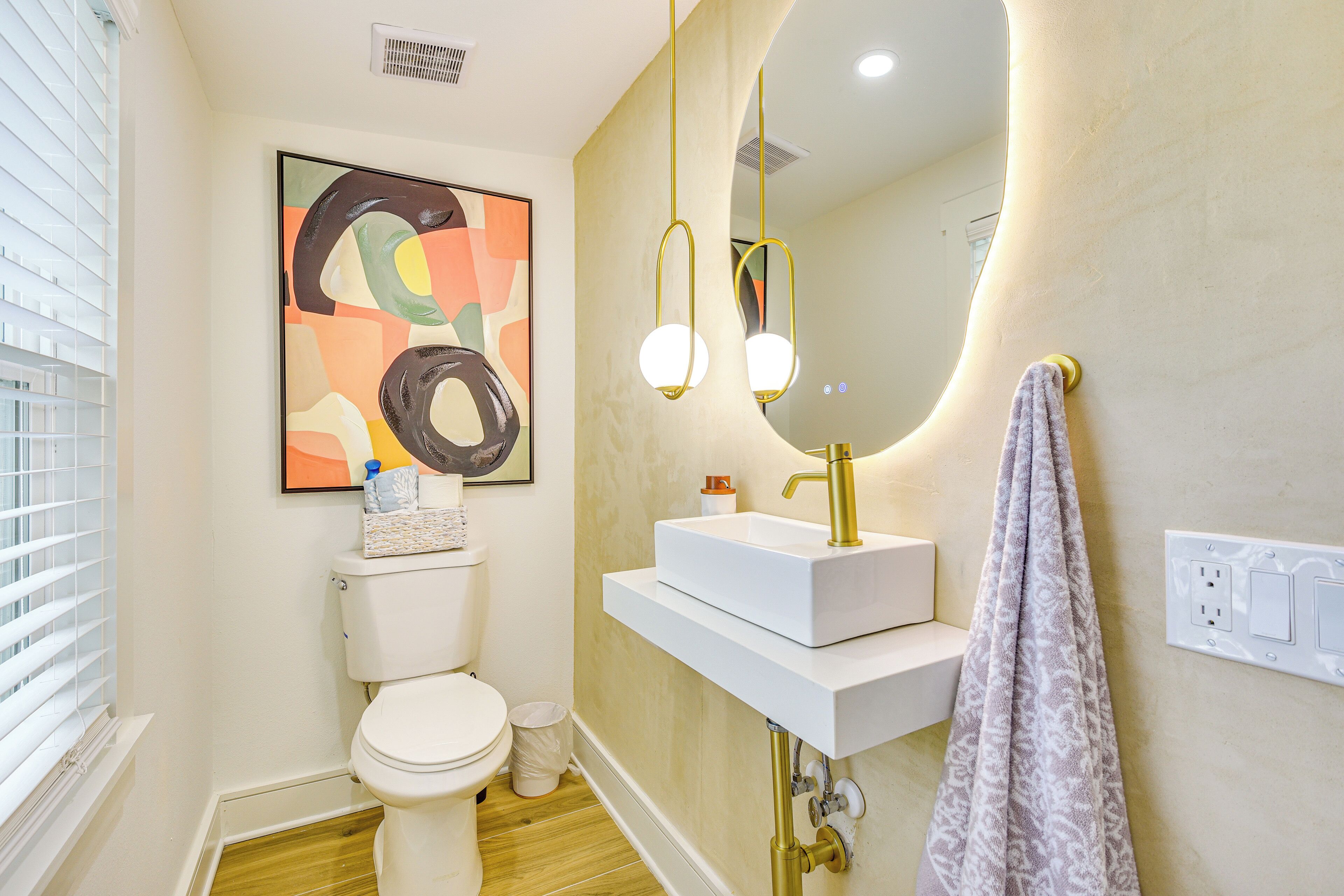 A modern bathroom with a toilet, sink, and mirror.