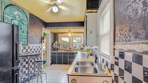 A kitchen with a bar area, a ceiling fan, and a view of the backyard. - 3 Mi to Dtwn: Unique Toledo Retreat (Toledo)