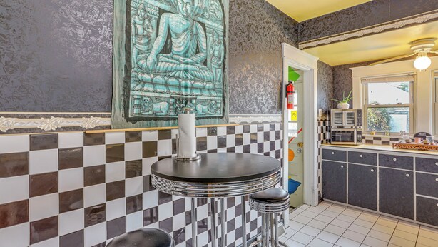 A kitchen with checkered tiles, a Buddha mural, and a microwave. - 3 Mi to Dtwn: Unique Toledo Retreat (Toledo)