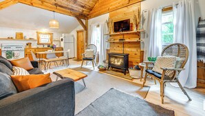A cozy living room with a fireplace, wooden furniture, and a dining area. - Fish & Water Raft: Cabin Near Lake Santeetlah (Robbinsville)
