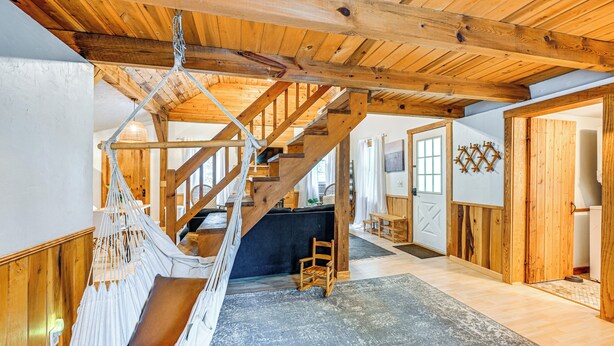 A wooden interior with a hammock chair, a staircase, and a rustic decor. - Fish & Water Raft: Cabin Near Lake Santeetlah (Robbinsville)