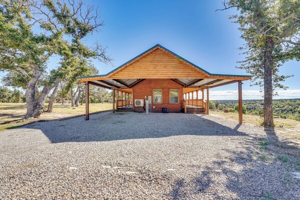 A wooden cabin with a covered porch, surrounded by trees and gravel. - 17 Mi to Tarleton State: Mtn-view Hideaway! (Stephenville)