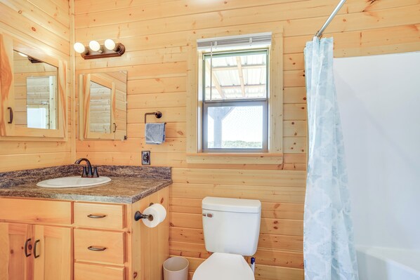 A wooden cabin bathroom with a sink, toilet, and a window with a view. - 17 Mi to Tarleton State: Mtn-view Hideaway! (Stephenville)